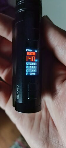 Zelos 3 e-cigarette held in hand, digital display shows 14 watts of power. (Subtitled by AI)