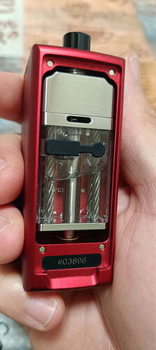 A red metal-bodied vape device with a transparent tank held in one hand is visible in the picture. (AI-generated caption)