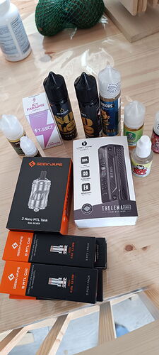 Az asztalon különböző e-cigaretta folyadékok, porlasztók és kiegészítők láthatók. (Feliratozva AI-val)