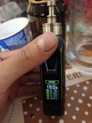 Egy kéz egy digitális kijelzős vape készüléket tart, amely 19,0 watt teljesítményt mutat. (Feliratozva AI-val)
