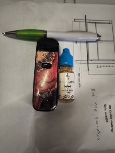 Un stylo vert et blanc, une cigarette électronique à motifs et un flacon compte-gouttes sont placés sur un papier. (Légendé par l'IA)