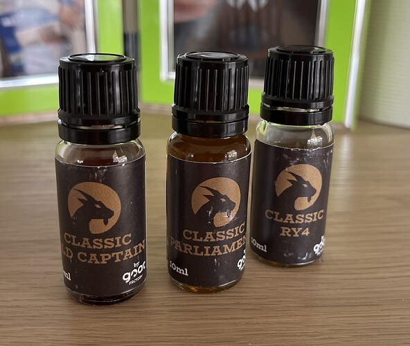 Three bottles of flavor liquid are visible, indicating different flavors, their names: Classic D Captain, Classic Parliament, and Classic RY4. (Captioned by AI)