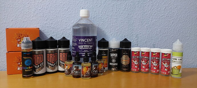In the image there are various available e-liquid bottles, a total of twelve bottles, as well as a larger Vincent branded liquid. (Subtitled by AI)