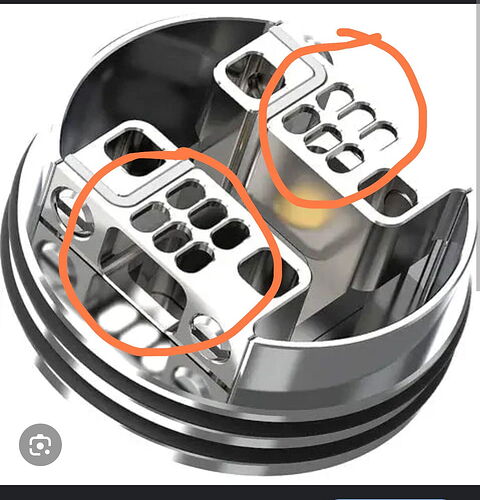 The image shows a metal part, likely the deck of an electronic cigarette RDA, with two wire guide slots marked in red. (Labeled by AI)