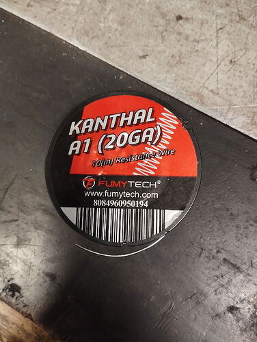 A képen egy Fumytech márkájú Kanthal A1 (20GA) ellenállás huzal található, piros és fekete címkével ellátva. (Feliratozva AI-val)