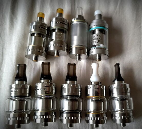 The image shows various vape tanks made of metal and glass parts. (Labeled by AI)