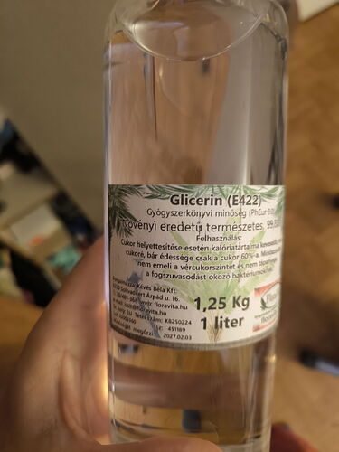 In the picture, a bottle of glycerin is visible, on its label there is text indicating the product's weight (1.25 kg) and volume (1 liter). (Labeled by AI)