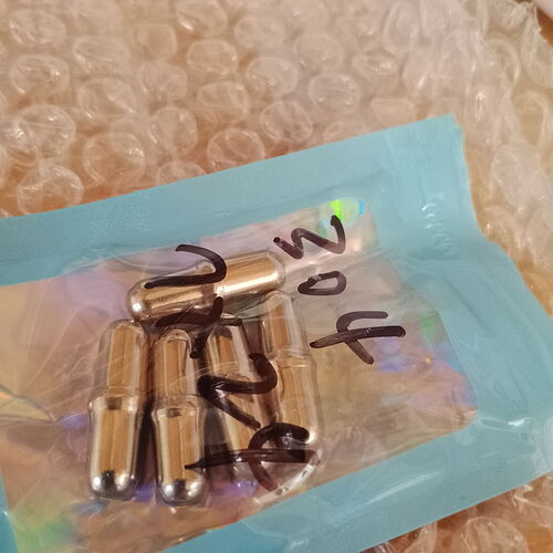 A few small, shiny metal objects are visible in a clear plastic bag with handwritten numbers on it, lying on bubble wrap. (Labeled by AI)