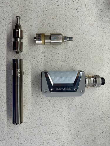 Az képen különböző vape eszközök láthatók, beleértve egy akkus modot, egy tankot és tartozékokat. (Feliratozva AI-val)