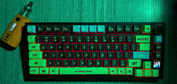 Sur l'image, un clavier thème Cyberpunk 2077 avec un cadre noir, équipé de touches vertes et bleues, et une vape de couleur brune sont visibles sur une surface en bois avec un éclairage vert. (Légendé par IA)