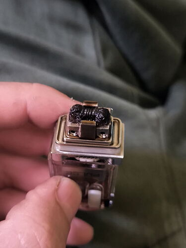 Une personne tenant une partie contenant une résistance de cigarette électronique en gros plan. (Sous-titré par l'IA)