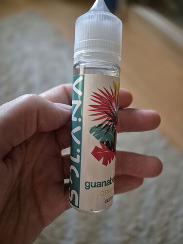 The image shows a guanabana flavored, colorful labeled, larger bottle of liquid held in someone's hand. (Labeled by AI)