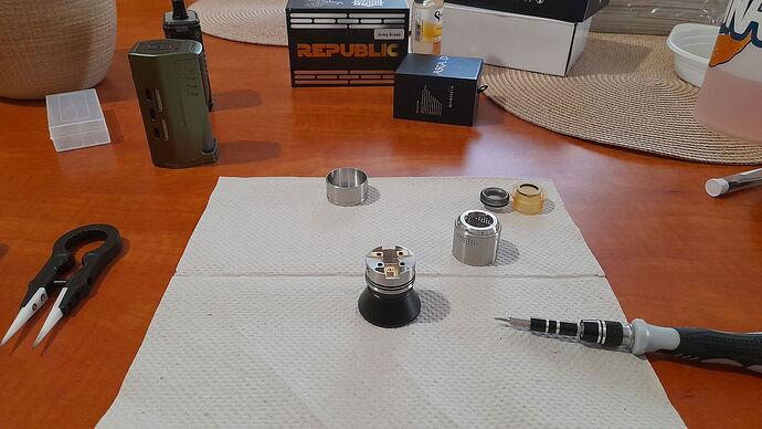 A disassembled electronic cigarette and a screwdriver are visible on a paper towel on the table. (Subtitled by AI)