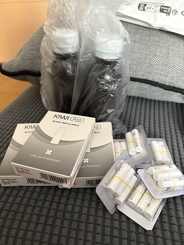 In the picture, two bottles wrapped in plastic, as well as several boxes and packs of filters are visible on a couch. (Subtitled by AI)