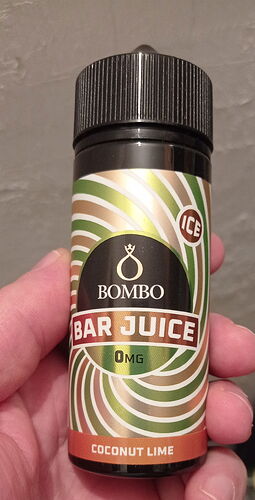 A képen egy kézben tartott Bombo Bar Juice ICE ízű, 0mg nikotint tartalmazó Coconut Lime e-liquid palackja látható. (Feliratozva AI-val)