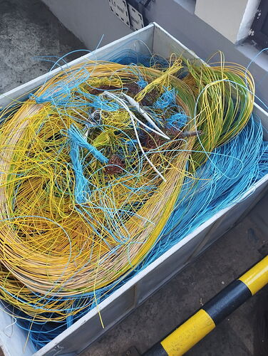 A large box contains a tangled heap of colorful wires. (Autotranscribed AI)