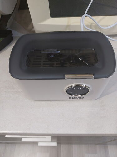 Un appareil de cuisine noir de marque Bialetti avec écran numérique est visible sur un plan de travail clair. (Sous-titré par IA)