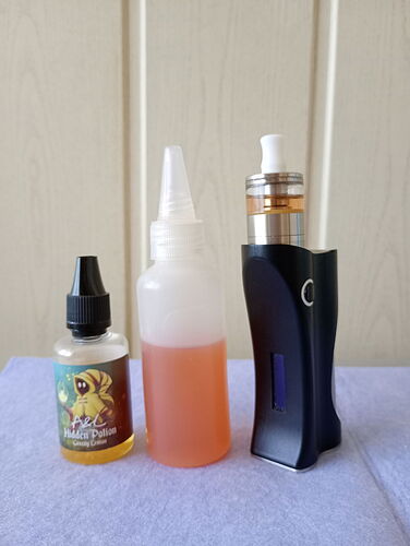 Három különböző méretű és formájú e-cigaretta folyadékadagoló és egy e-cigaretta készülék egymás mellett egy kék felületen. (Feliratozva AI-val)