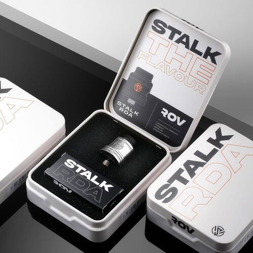 Three children sit at a table, drawing and coloring, one of them is kneeling on their chair. (Subtitled by AI)