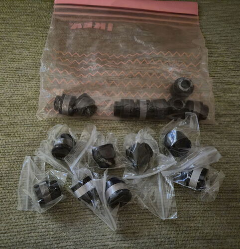 Az képen egy Ziploc műanyag tasakban és külön kis műanyag zacskókban elhelyezett fekete műanyag alkatrészek láthatók, valószínűleg csatlakozók vagy szelepek. (Feliratozva AI-val)