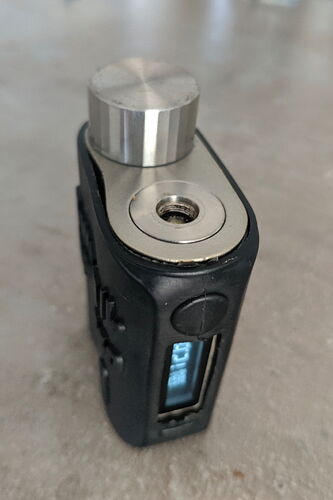 The image shows an electronic smoking device made of a combination of metal and plastic, with a digital display. (AI-generated caption)