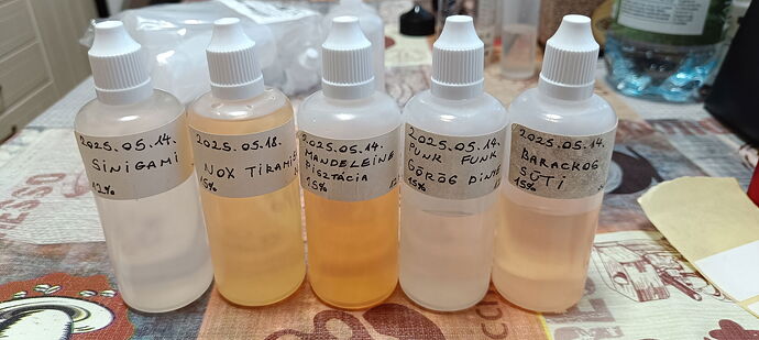 Five different labeled plastic dropper bottles are on the table, containing various solutions or liquids. (Labeled by AI)