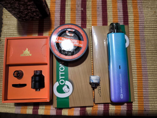 Az ábrán különféle elektronikus cigaretta alkatrészek és tartozékok láthatók színes csíkos alapon elhelyezve. (Feliratozva AI-val)