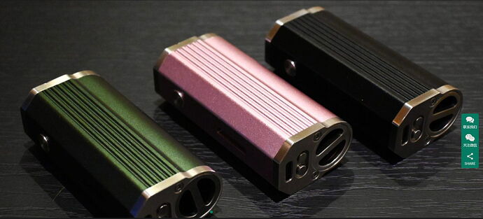 In the picture, three different colored (green, pink, and black) compact, metal-cased devices are visible on a black surface. (Labeled by AI)