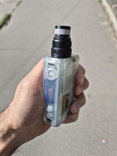 Une main tenant une cigarette électronique (vape) avec un boîtier transparent fait maison et un embout buccal noir. (Sous-titré par IA)