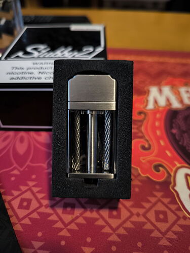 The image contains a modern vape device placed inside a black box. (Autogenerated by AI)