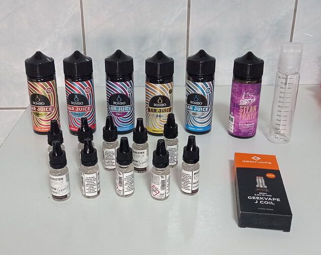Various flavored vape liquids and a device used for electronic smoking are visible in the picture. (AI-generated caption)