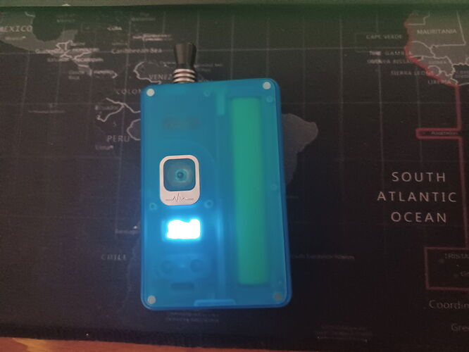 The image shows an electronic device in a blue, transparent case against a background of a globe map. (Captioned by AI)