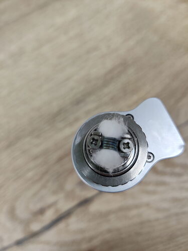 The image shows a round metal component partially covered with white cotton material. (AI-captioned)