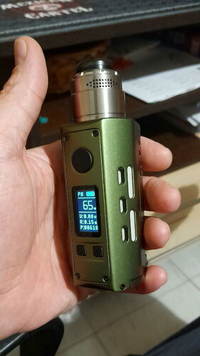 Egy kézben tartott, zöld színű, digitális kijelzős vape eszköz látható. (Feliratozva AI-val)