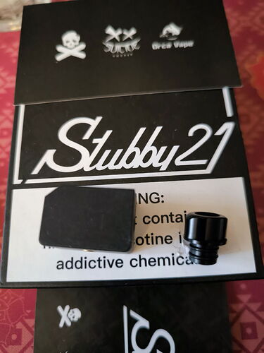 A black package with a Stubby21 logo is shown in the image, along with a black plug and a metal, screw-like part. (Autogenerated by AI)