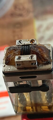 L'image montre une cigarette électronique (vape) avec une résistance, sur laquelle le rembourrage ou la bobine brûlé ou usé est visible. (Légendé par IA)