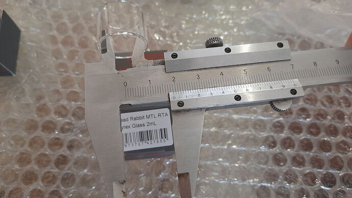 Az [image] egy üveget mér egy tolómérő buborékos fólia hátterében. (Feliratozva AI-val)