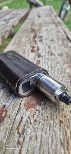 A metal and leather smoking device on a wooden bench. (Subtitled with AI)