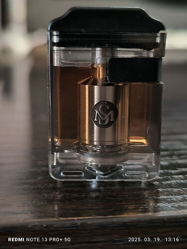 The image shows a transparent vape cartridge containing a golden atomizer. (Labeled by AI)