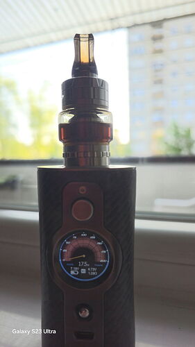 A black vape device with a digital display is shown standing on a windowsill. (Labeled by AI)