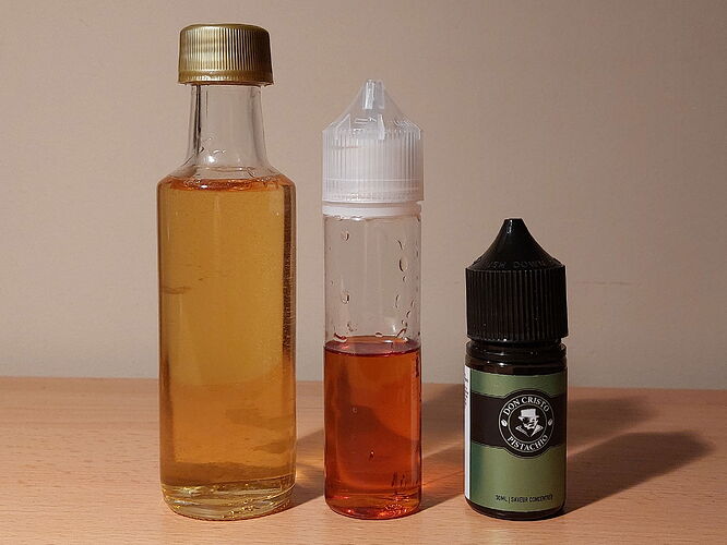 In the picture, three bottles are visible, containing liquids of different colors and sizes, likely vape or flavored oils. (Labeled by AI)