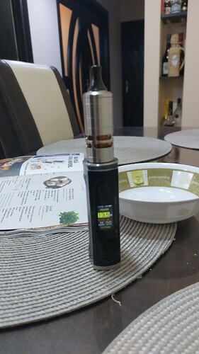 The image shows an e-cigarette on a table, with a plate and a menu around it. (Captioned by AI)