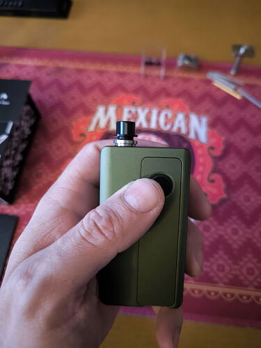 A green vape device is shown in the image, held by a hand. (Autogenerated by AI)