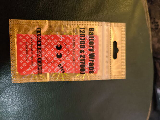 The image shows a gold bag with red, funny face patterned battery wraps inside. (Subtitled by AI)