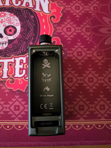 A black device is shown in the image, with various symbols and inscriptions, and a colorful, skull design as the background. (Autogenerated by AI)