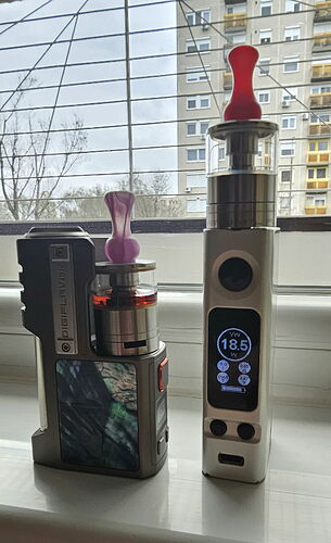 The image shows two different vaping devices, which are standing on a windowsill, a residential building can be seen in the background. (Subtitled by AI)